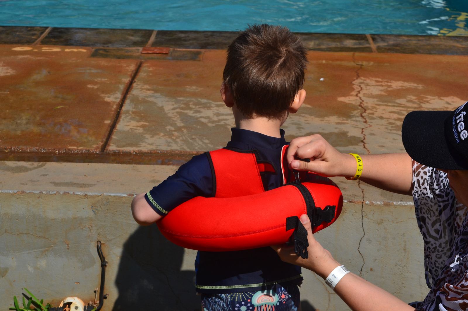 Mum fastening the Water-Bugs zip on her son